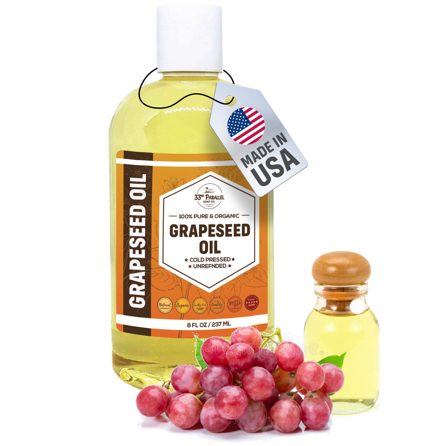 Bottle of grapeseed oil with a tag indicating 'Made in USA', surrounded by grapes on a white background.